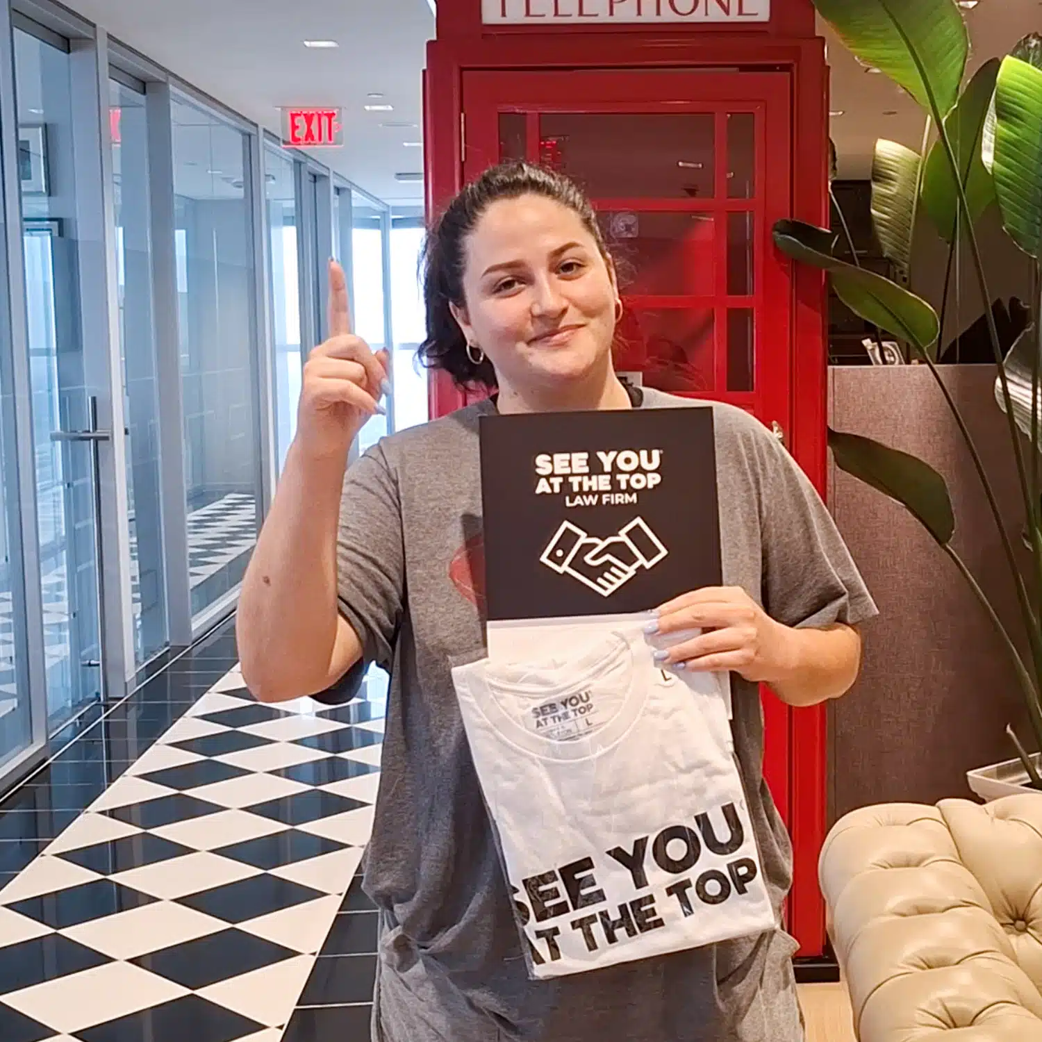 Person holding promotional law firm shirts.